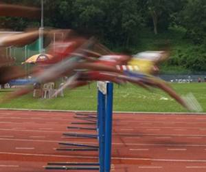 Detalhe do movimento de salto dos atletas sobre a barreira.